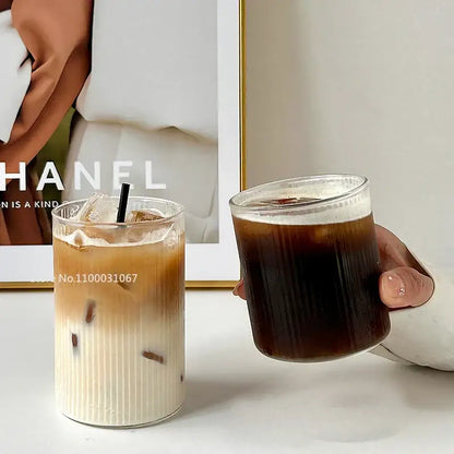 Hammered clear glass cafe coffee cup tumbler with ribbed texture filled with iced coffee by decorbites glass cafe