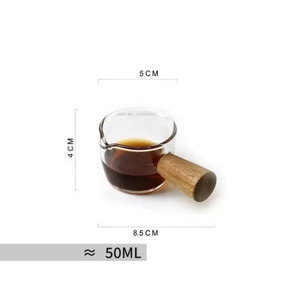 Hammered clear glass cafe coffee cup with wooden handle filled with dark liquid by decorbites glass cafe