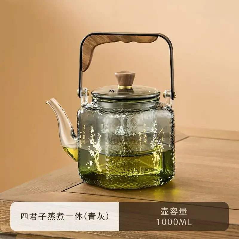 Hammered floral glass teapot with green-tinted textured body white floral etchings and bronze handle decorbites glass teapot