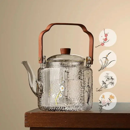 Clear glass teapot with hammered texture and hand-painted floral bamboo design featuring wooden lid and bronze handle decorbites glass teapot