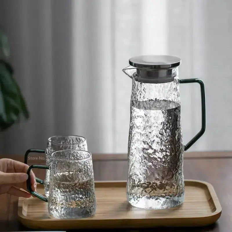 Clear hammered gray amber water pitcher with sleek black handle and stainless steel lid with matching decorbites tumblers