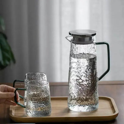Clear hammered gray amber water pitcher with sleek black handle and stainless steel lid with matching decorbites tumblers