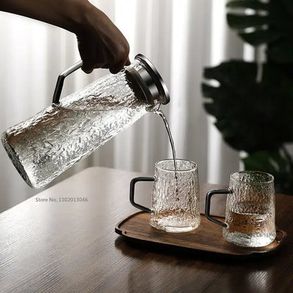 Clear textured gray amber water pitcher with stainless steel lid pouring liquid into matching mugs decorbites gray amber water pitcher