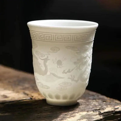 Delicate white porcelain tea cup set featuring embossed dragon cloud motifs and greek key pattern for dining room use