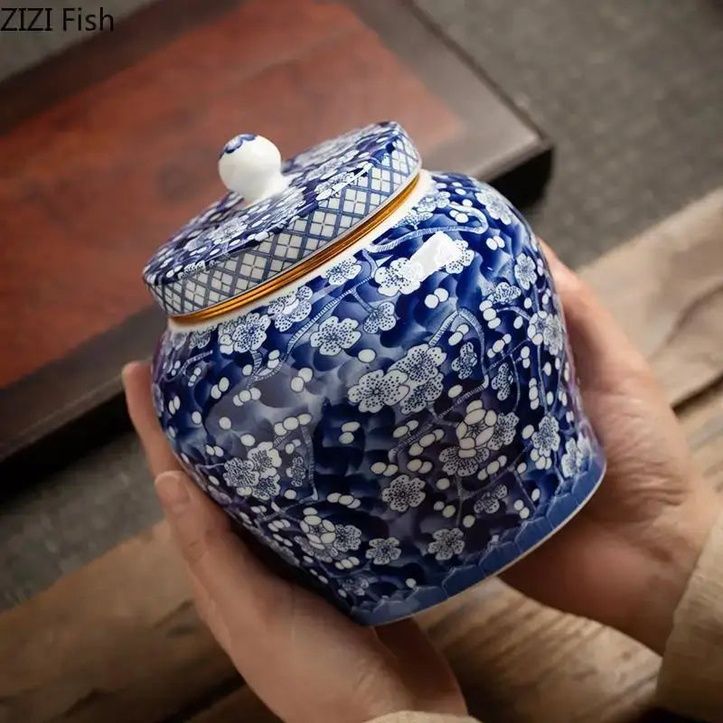 Hand-painted white porcelain tea canister with blue and white ceramic, plum blossom patterns, and gold trim