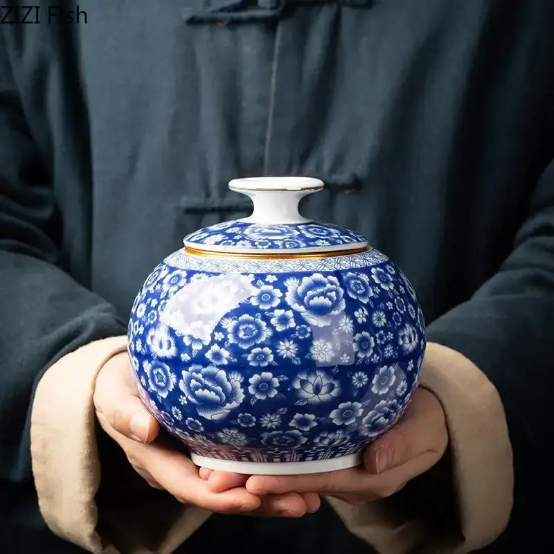 Round blue and white porcelain tea canister with intricate floral patterns and a gold-trimmed lid for kitchen storage