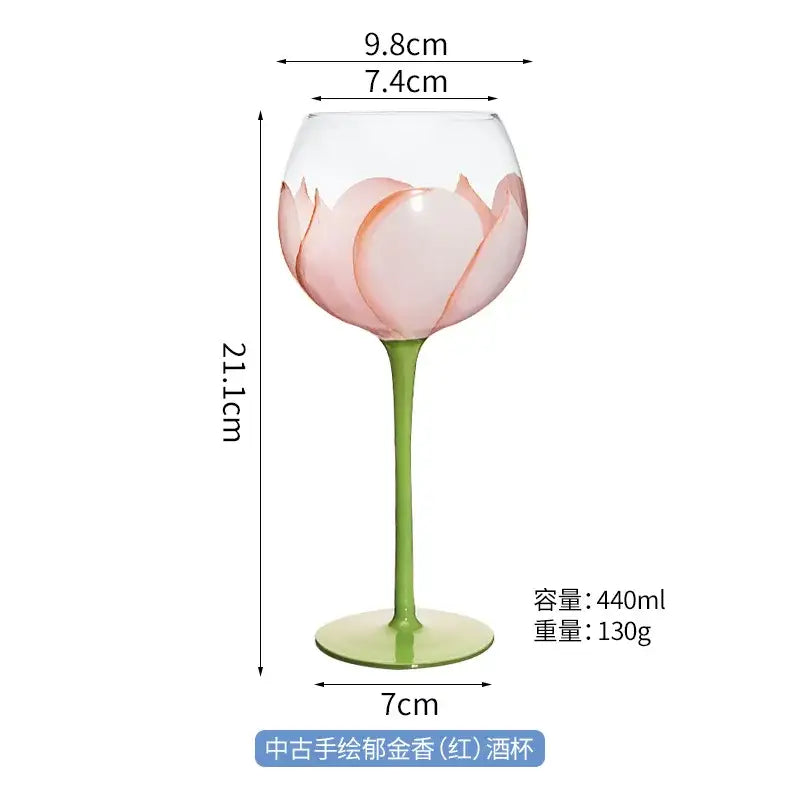 Delicate hand painted glass goblet with pink lotus floral design and slender green stem for elegant dining room decor