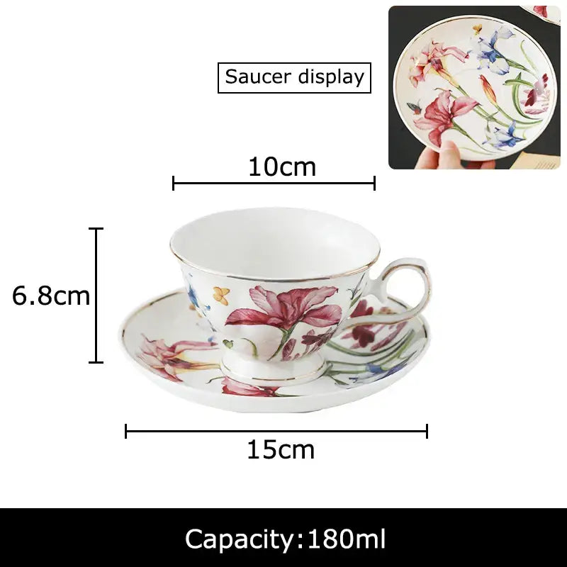 A hand painted iris flower porcelain teacup and saucer with vibrant pink blue and green floral patterns on white background