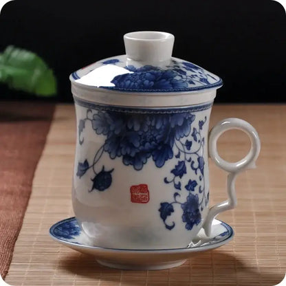 Hand painted lotus white porcelain tea cup with filter featuring blue floral patterns and a red seal mark on its side