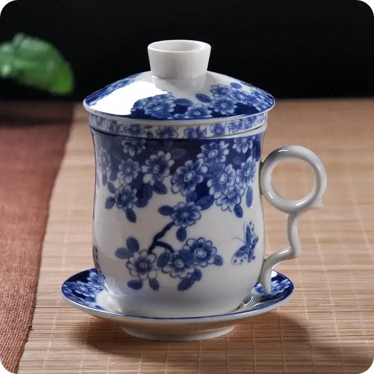 Hand painted lotus white porcelain tea cup with filter featuring blue floral and butterfly design with lid and saucer