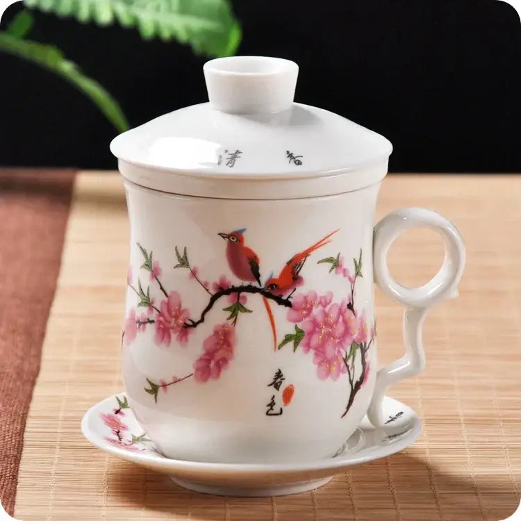 White porcelain tea cup with lid and saucer hand painted with pink cherry blossoms and red birds for dining room use