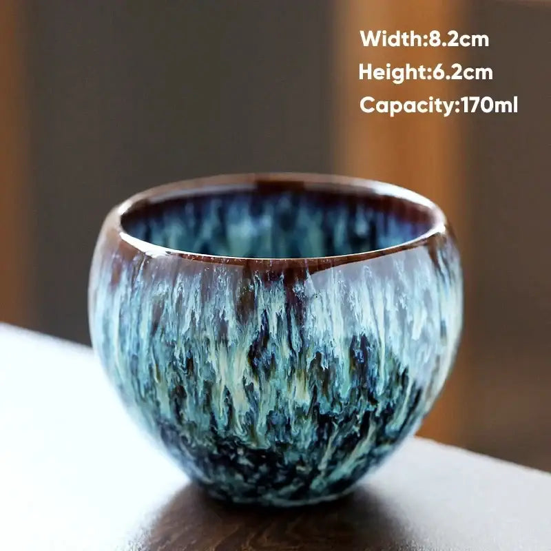 Handcrafted ceramic coffee cup with swirling blue and brown crackle glaze and glossy finish for dining room use