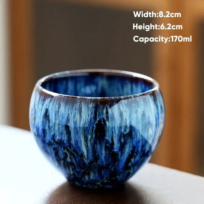 Handcrafted ceramic coffee cup with a deep blue and black crackle glaze and glossy finish for dining room use