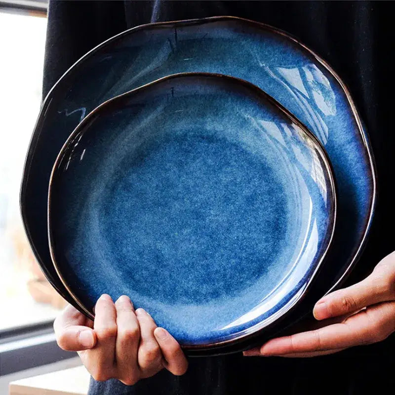 Two handcrafted ceramic dessert plates with a deep blue gradient glaze and irregular organic edges decorbites deep blue
