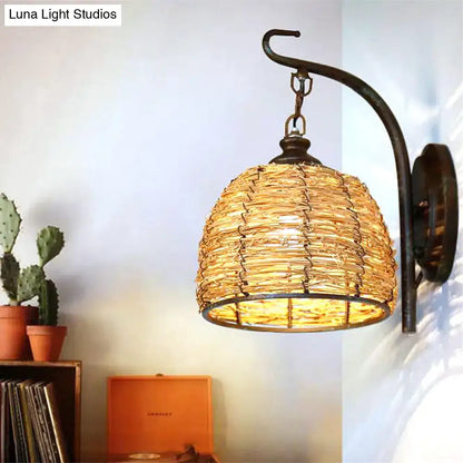 Handmade asian rattan dome wall sconce with woven natural fiber shade and dark bronze curved wrought iron arm fixture type