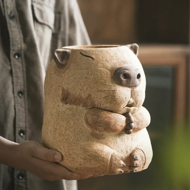 A beige ceramic groundhog planter with textured fur patterns for use as a handmade carbon oven surrounding stove warmer