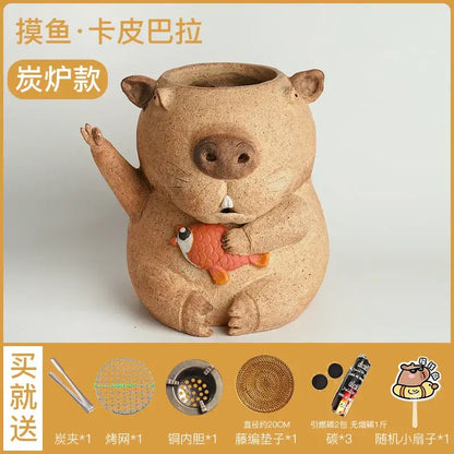 Tan ceramic pig-shaped charcoal burner holding small orange fish figurine for carbon oven surrounding stove use