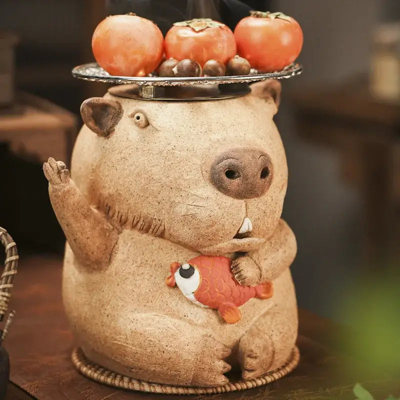 Handmade tan ceramic beaver figurine holding orange fish with persimmons on head for refractory carbon oven surrounding