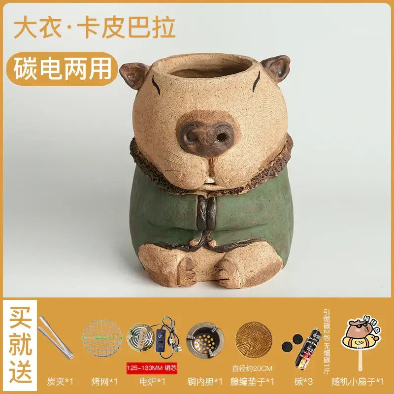A charming beige ceramic handmade capybara carbon oven surrounding stove tea warmer with green robe and brown fur trim