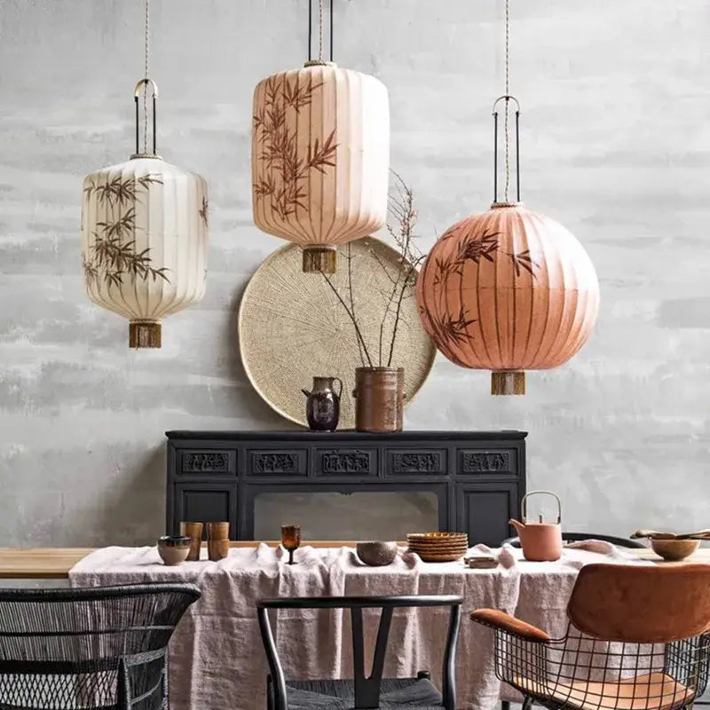 Three hanging cream and peach bamboo lantern pendant lights with bamboo leaf designs from decorbites bamboo lantern collection