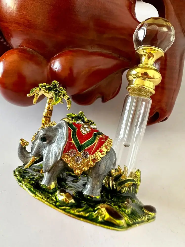 Handmade silver elephant crystal perfume bottle with red and green embroidered saddle, gold accents, and crystal embellishments