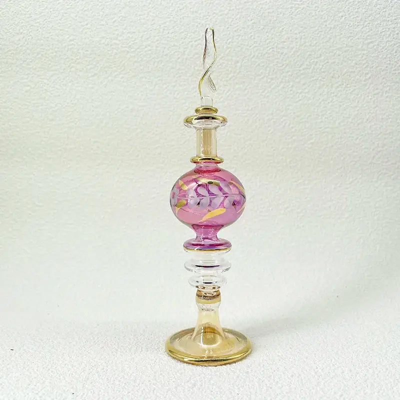 Delicate pink handmade glass bottle with gold accents and twisted stopper as an exquisite ornament for living room decor