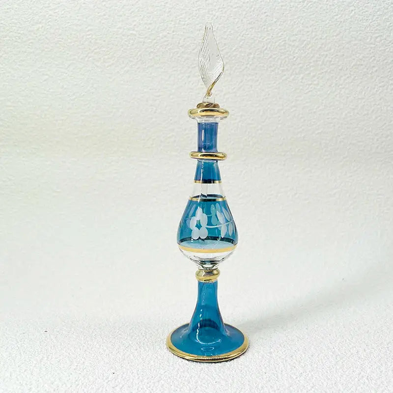 Slender elegant blue handmade glass bottle with gold accents and white floral etchings exquisite ornament for decor