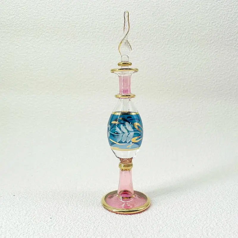 Handmade glass bottle with blue and gold leaf design, pink accents, and ornate stopper as exquisite ornament for decor