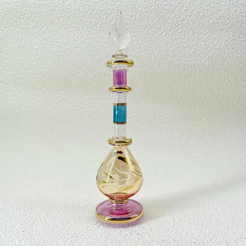 A slender handmade glass bottle with gold accents and a fluted stopper as an exquisite ornament for living room decor