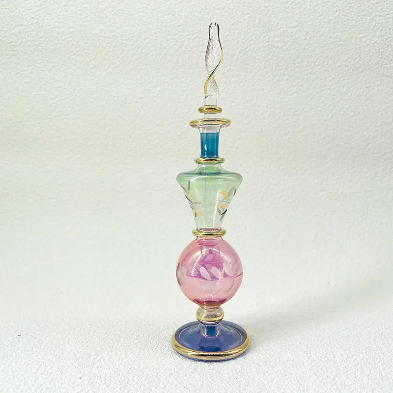 Handmade glass bottle with gold accents and soft green pink blue hues as an exquisite ornament for living room decor