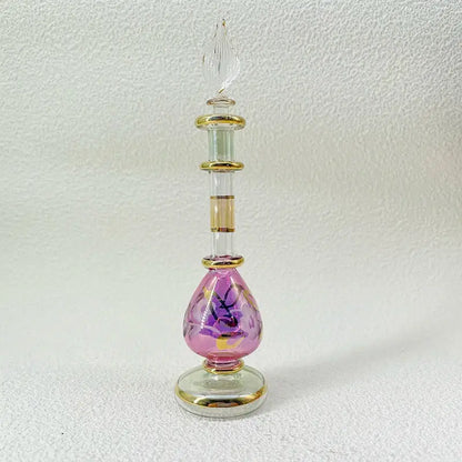 A delicate pink handmade glass bottle with gold accents and purple floral designs, an exquisite ornament for decor