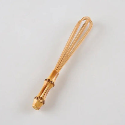 Handmade golden bamboo egg beater flour mixer with decorative segmented handle and fine wire loops for blending