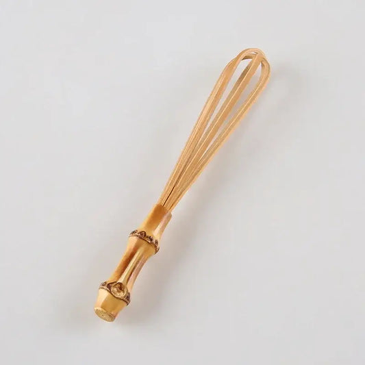 Handmade golden bamboo egg beater flour mixer with decorative segmented handle and fine wire loops for blending