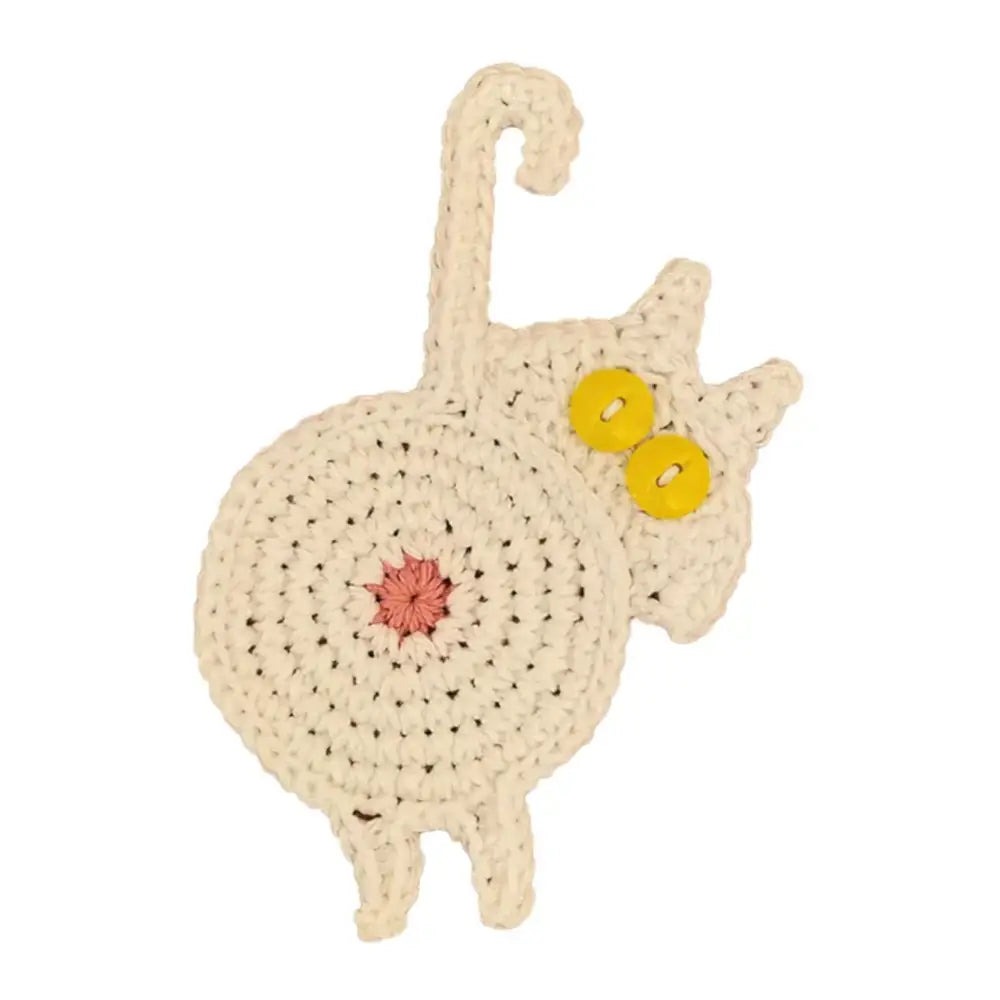 Handmade cream-colored crocheted decorbites cat butt coaster with yellow button eyes and pink embroidered center