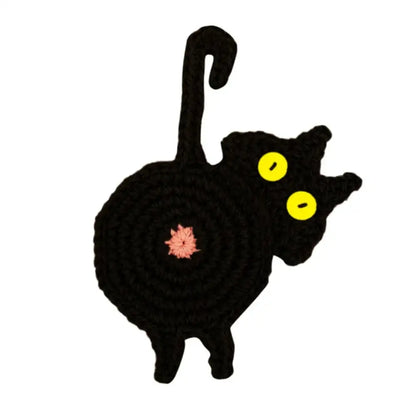 Handmade black crocheted cat butt coaster with bright yellow eyes and pink flower by decorbites cat butt set