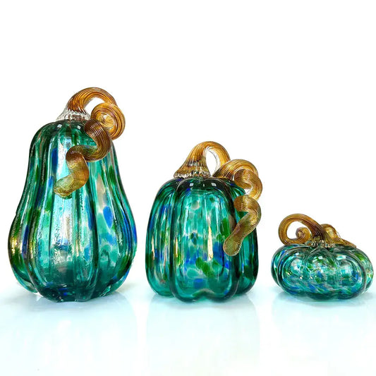 Set of three handmade iridescent teal and green glass pumpkin figurines with gold-tinted stems for living room decor