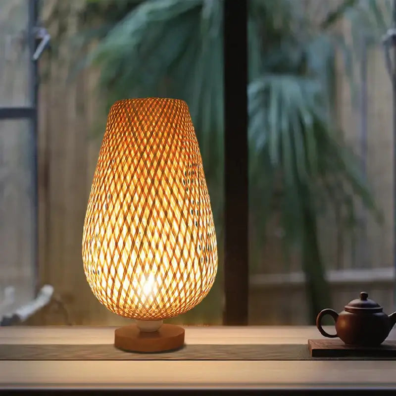 Warm-toned bamboo table lamp with woven lattice design and wooden base for bedroom use