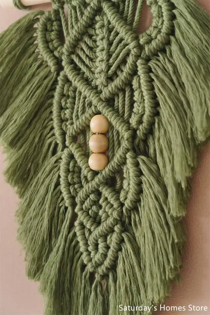 Handmade macrame leaf wall hanging in olive green with wooden bead accents for off-white bedroom decor