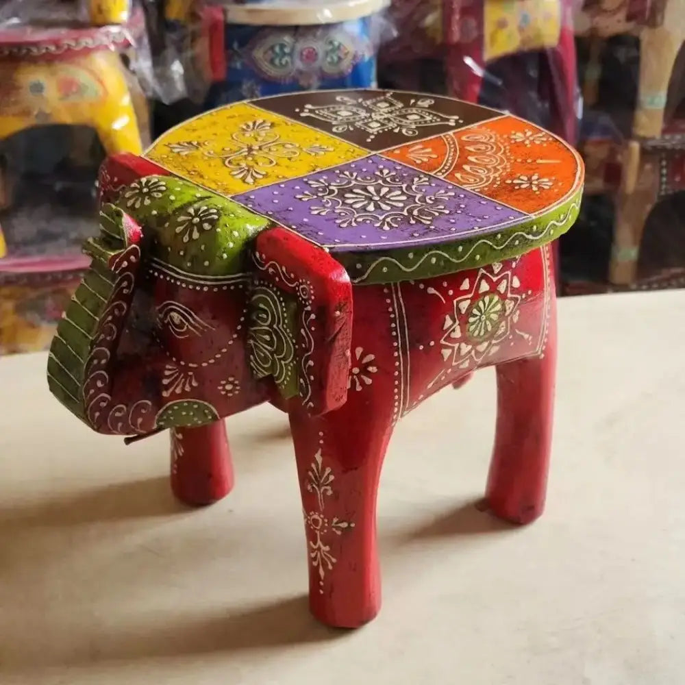 Hand-painted vibrant red wooden elephant stool with colorful patterned top and white floral designs by decorbites for living room decor