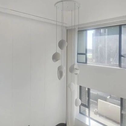 Modern white ceramic handmade wabi sabi pendant lights with organic sculptural shapes hanging from circular mount