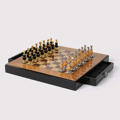 Elegant black and gold handmade wooden chess set with polished pieces on a glossy board in a sleek storage tray