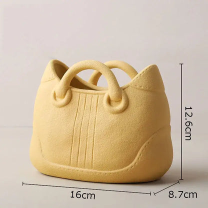 Pale yellow ceramic vase shaped like a handbag with stitched detailing by decorbites handwoven ceramic vase collection