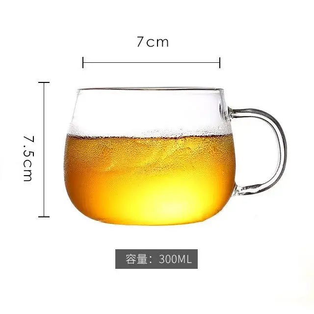 Clear glass mug with handle filled with golden liquid next to a heat resistant glass pitcher water carafe with stainless lid