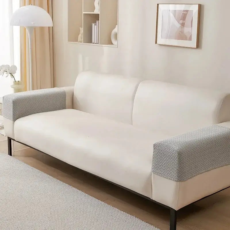 Cream-colored sofa with knit fleece herringbone armrest covers in textured gray fabric and black metal legs