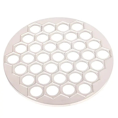 Silver honeycomb-patterned metal trivet paired with a black aluminum dumpling maker mold kitchen tool for dumpling making