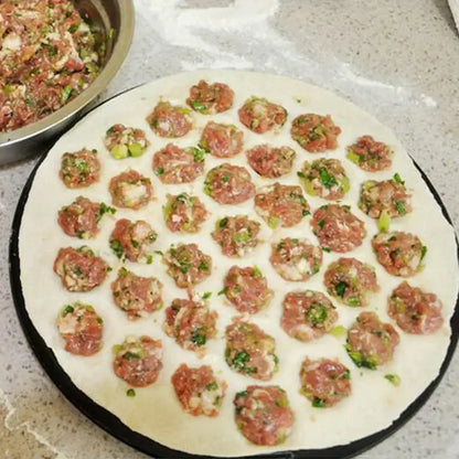 Hexagonal black aluminum dumpling maker mold with a round flat dough base filled with meat and herbs in a grid pattern