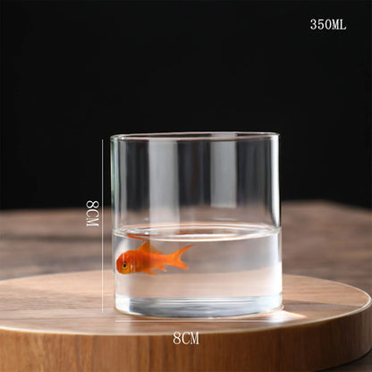 A clear glass tumbler hydroponics planter vase with an orange goldfish inside for desktop home decoration