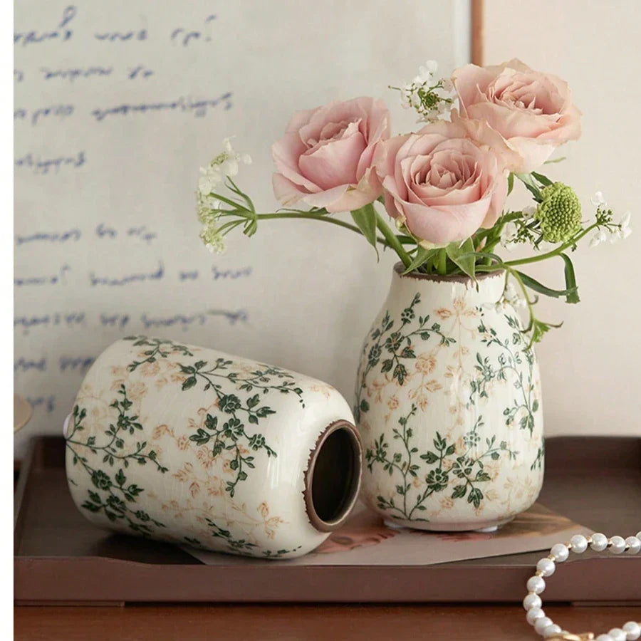 Cream-colored ice crackle ceramic vase with green floral patterns holding pink roses for home decoration