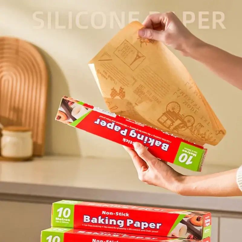 Illustrated grease-resistant baking paper in red and green packaging with 10-meter brown silicone-coated roll unrolling