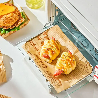 Golden-brown sausage rolls on grease-resistant illustrated baking paper in a toaster oven for kitchen food wrapping